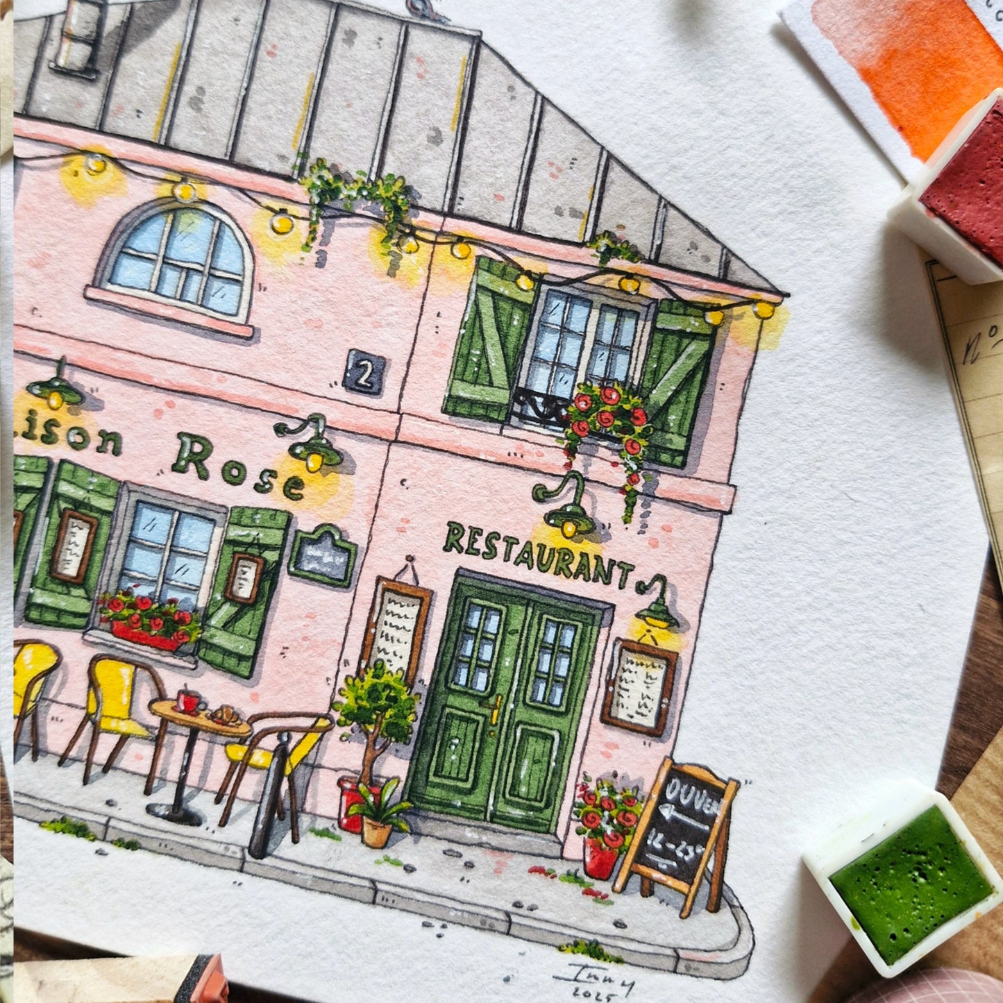 Pink illustration of a restaurant named La Maison Rose' with a street scene. and entrance