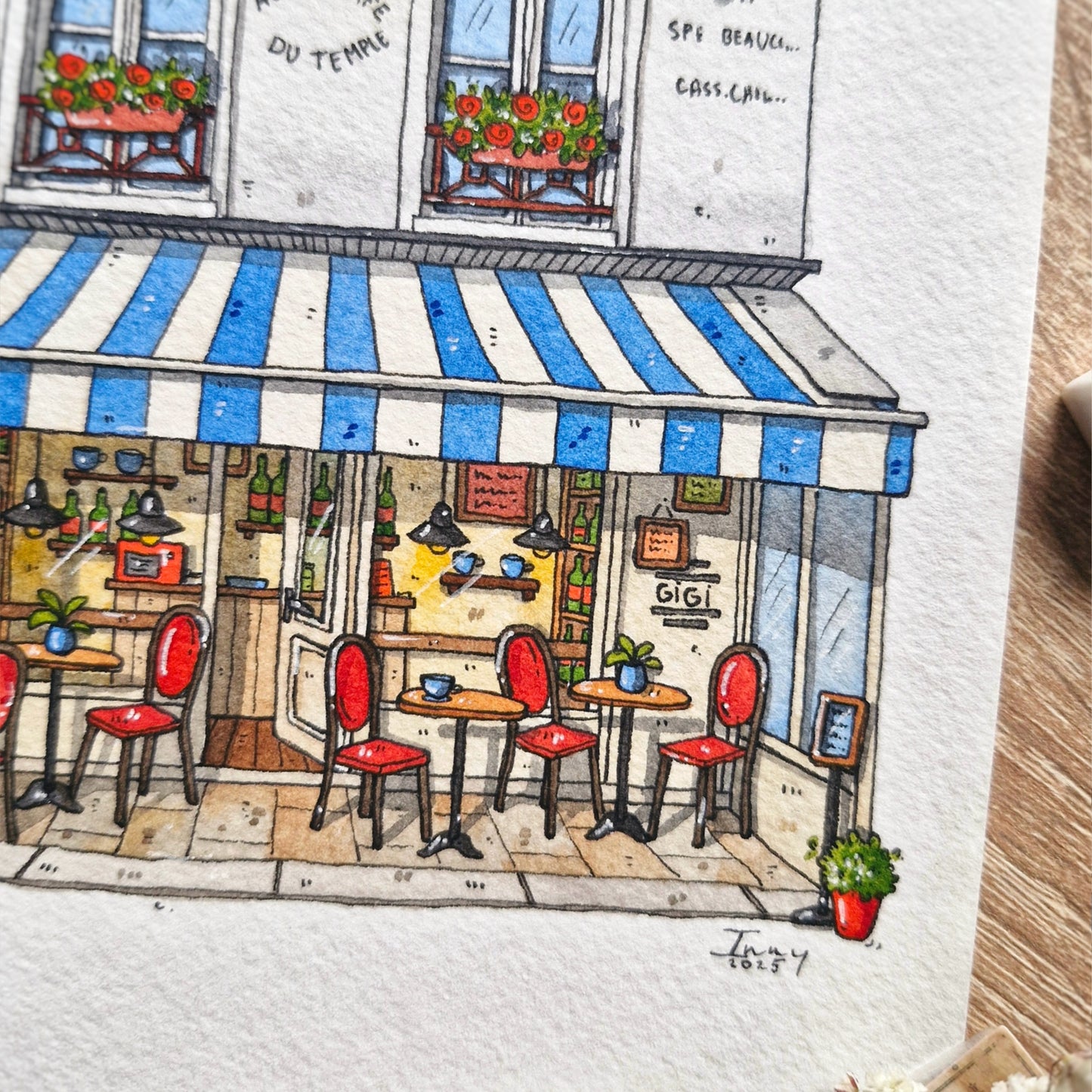 Illustration of a charming cafe with a blue and white striped awning, red chairs, and tables.