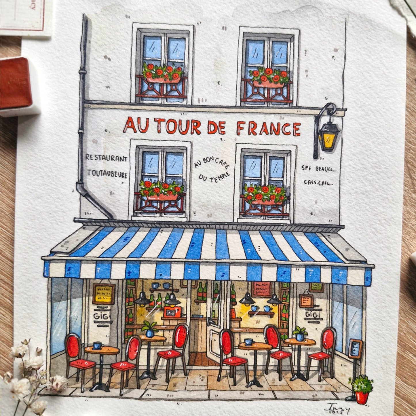 Illustration of a French cafe named 'Au Tour de France - gigi creperie with a striped awning.