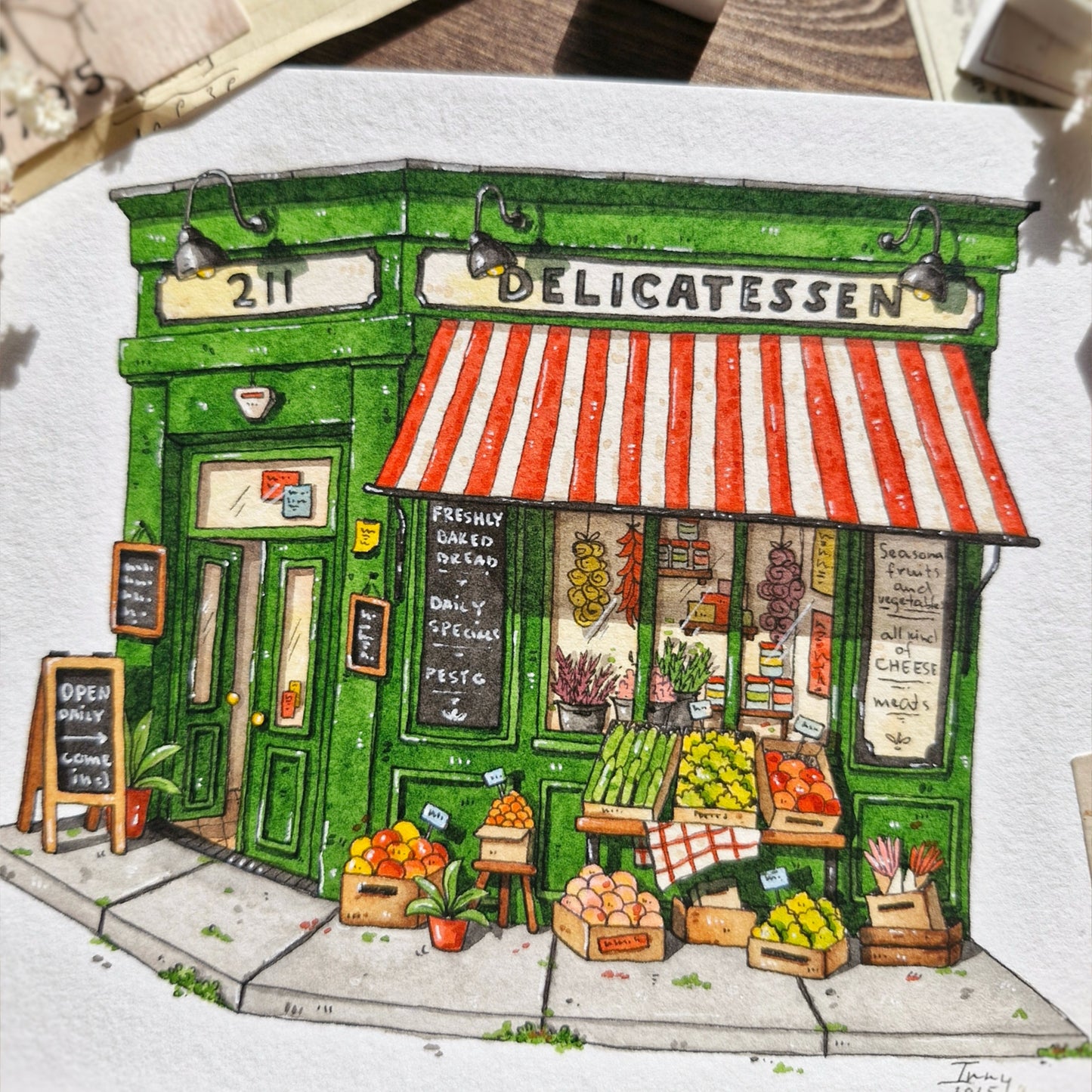 watercolor and ink custom painting of a deli with a green facade and red and white striped awning.