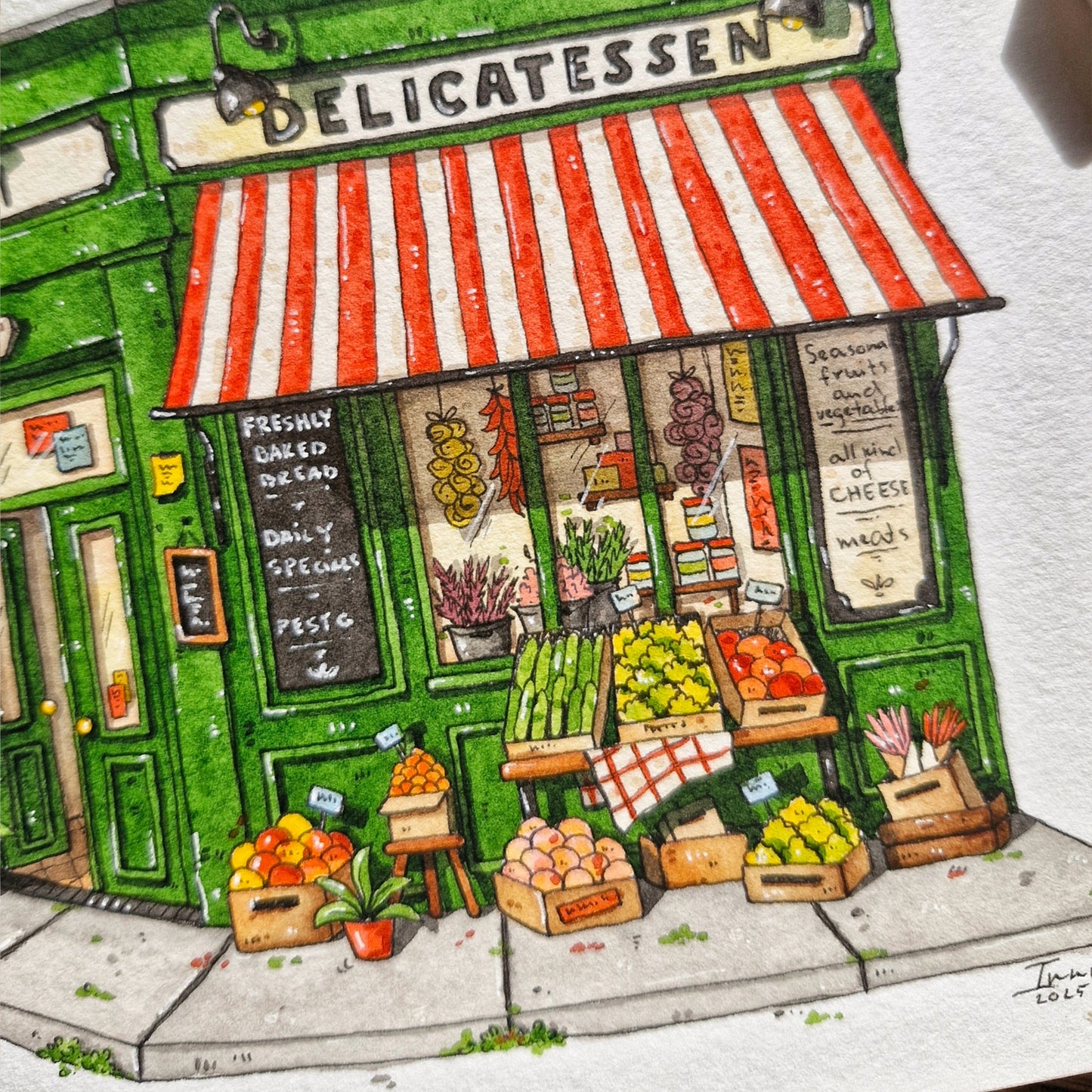 watercolor and ink painting closeup of a deli with a striped awning and fresh produce.