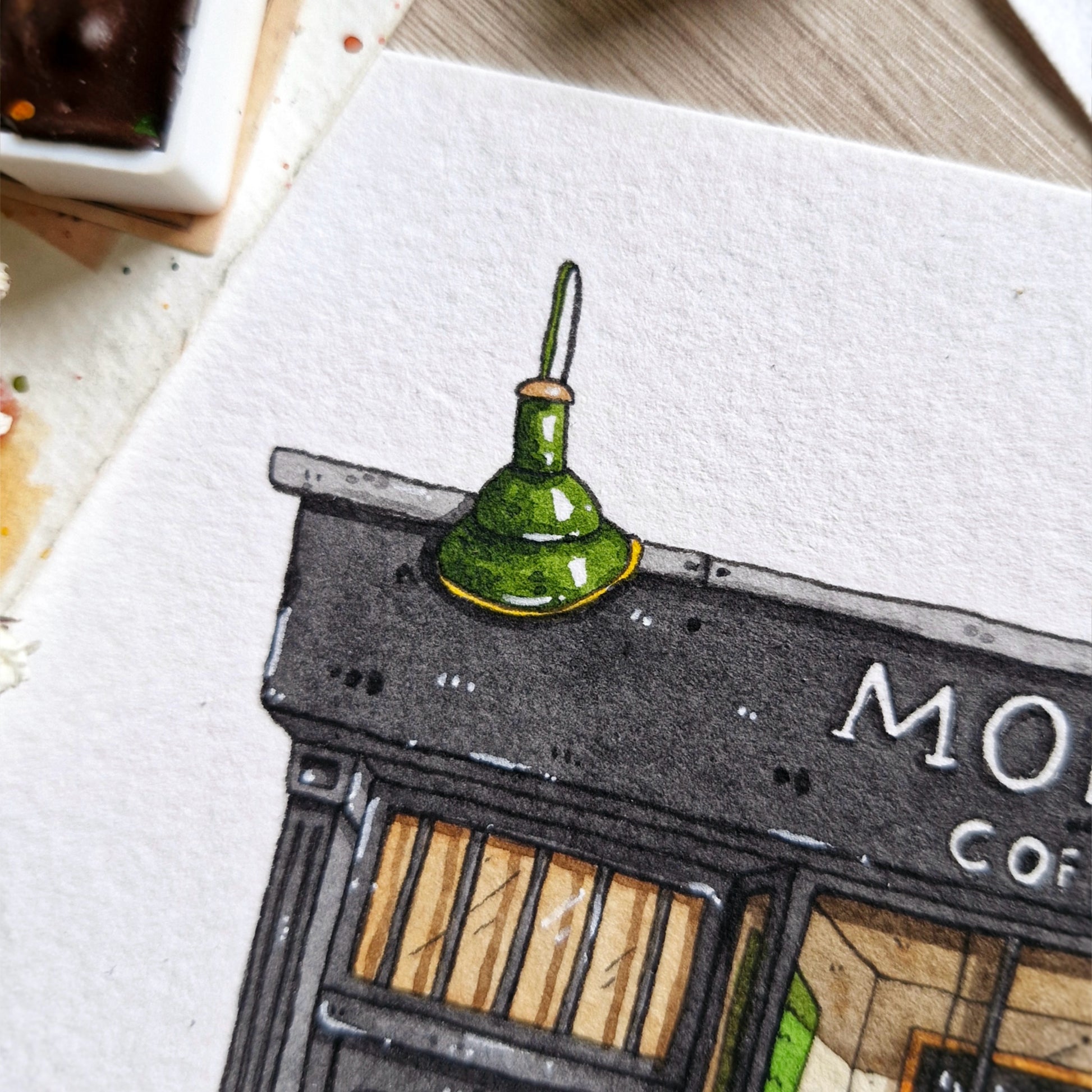 closeup of the hand painted green lamp that is on top of the monmouth coffee company in London