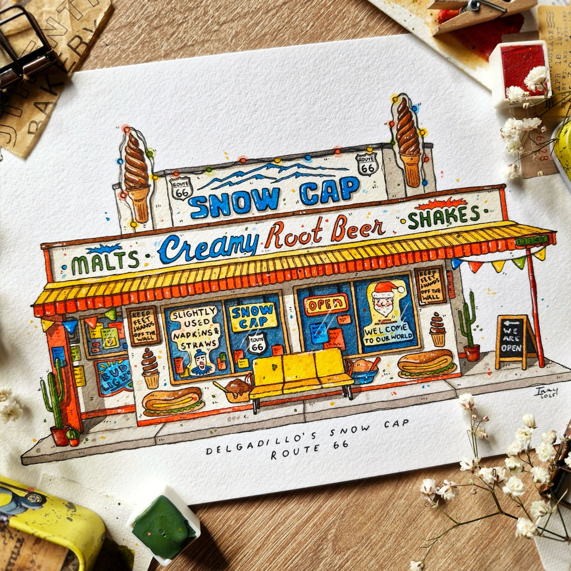 watercolor and ink painting by inky paper house of a Snow Cap ice cream stand with vintage decor on a wooden surface.