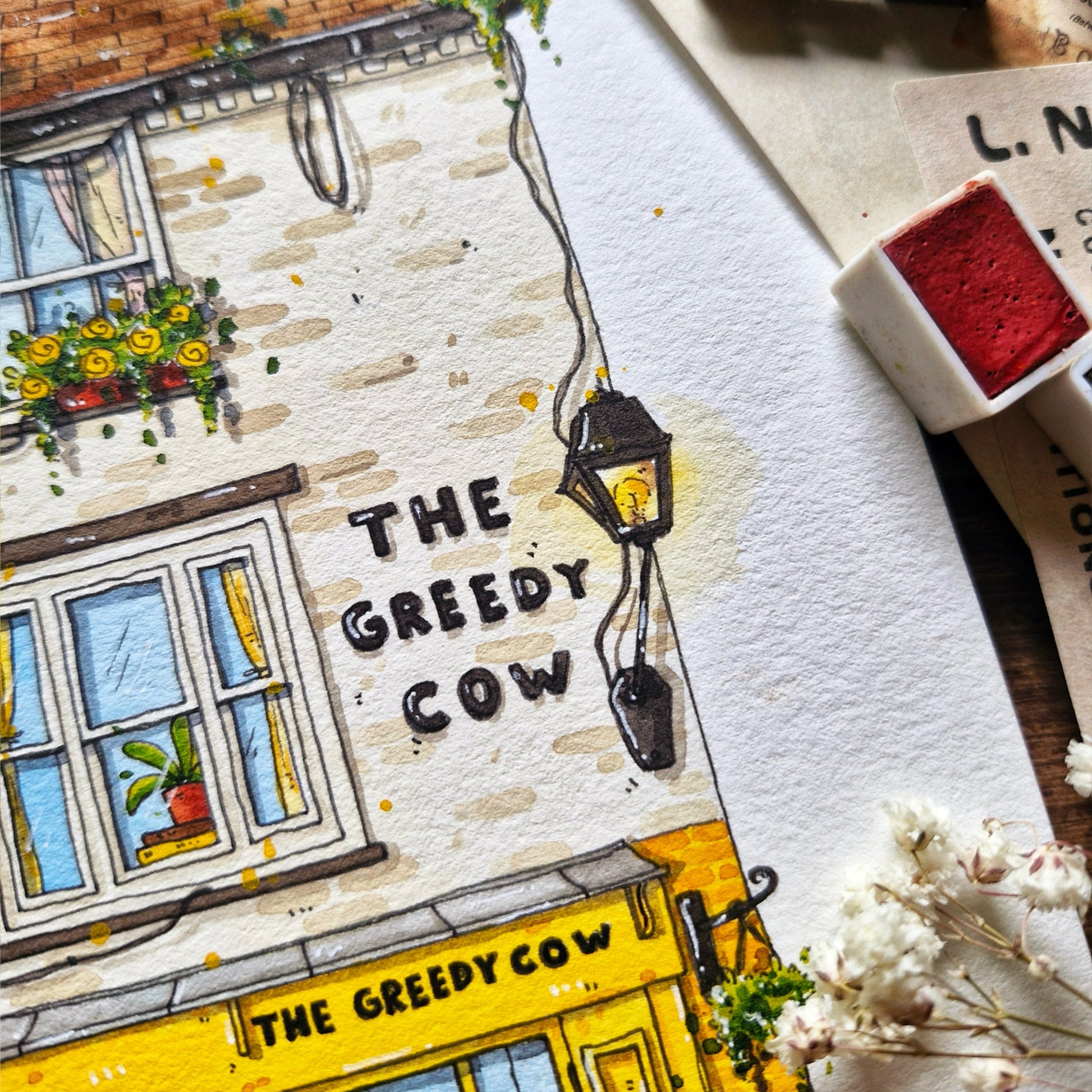 watercolor and ink painting of a building with 'The Greedy Cow' sign, featuring a yellow storefront and decorative elements.
