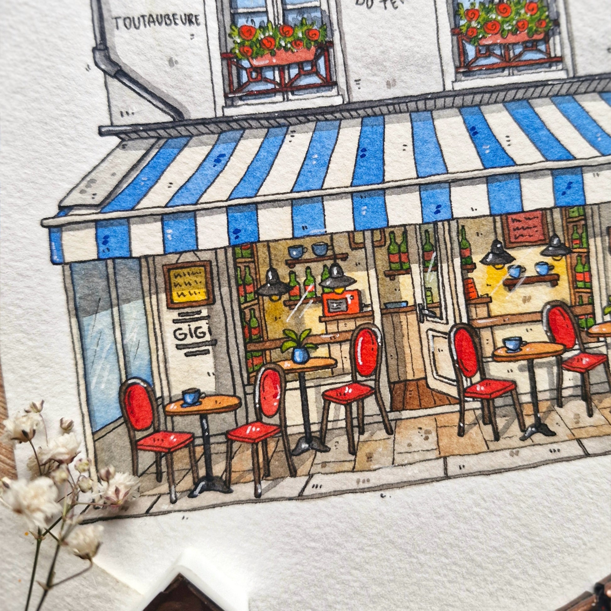 watercolor and ink Illustration of a cozy café with red chairs and a blue and white striped awning.