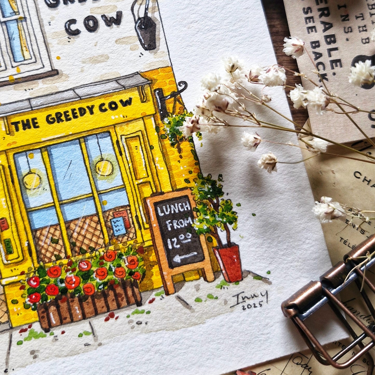 Illustration of a restaurant named 'The Greedy Cow' with flowers and a sign on a textured surface.
