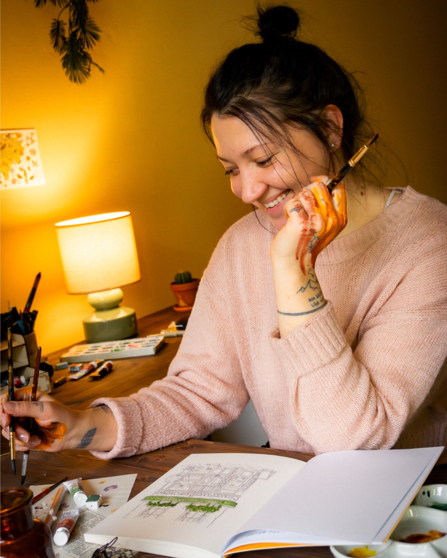 Woman sitting at a table with a coloring book smiling.