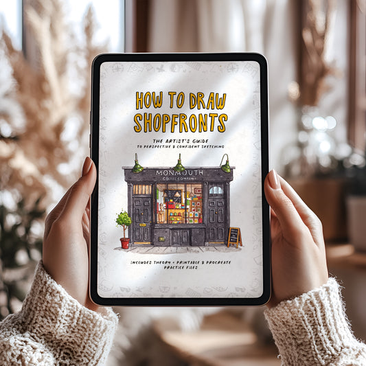 Person holding a tablet with an eBook cover titled 'How to Draw Shopfronts' displayed on the screen.